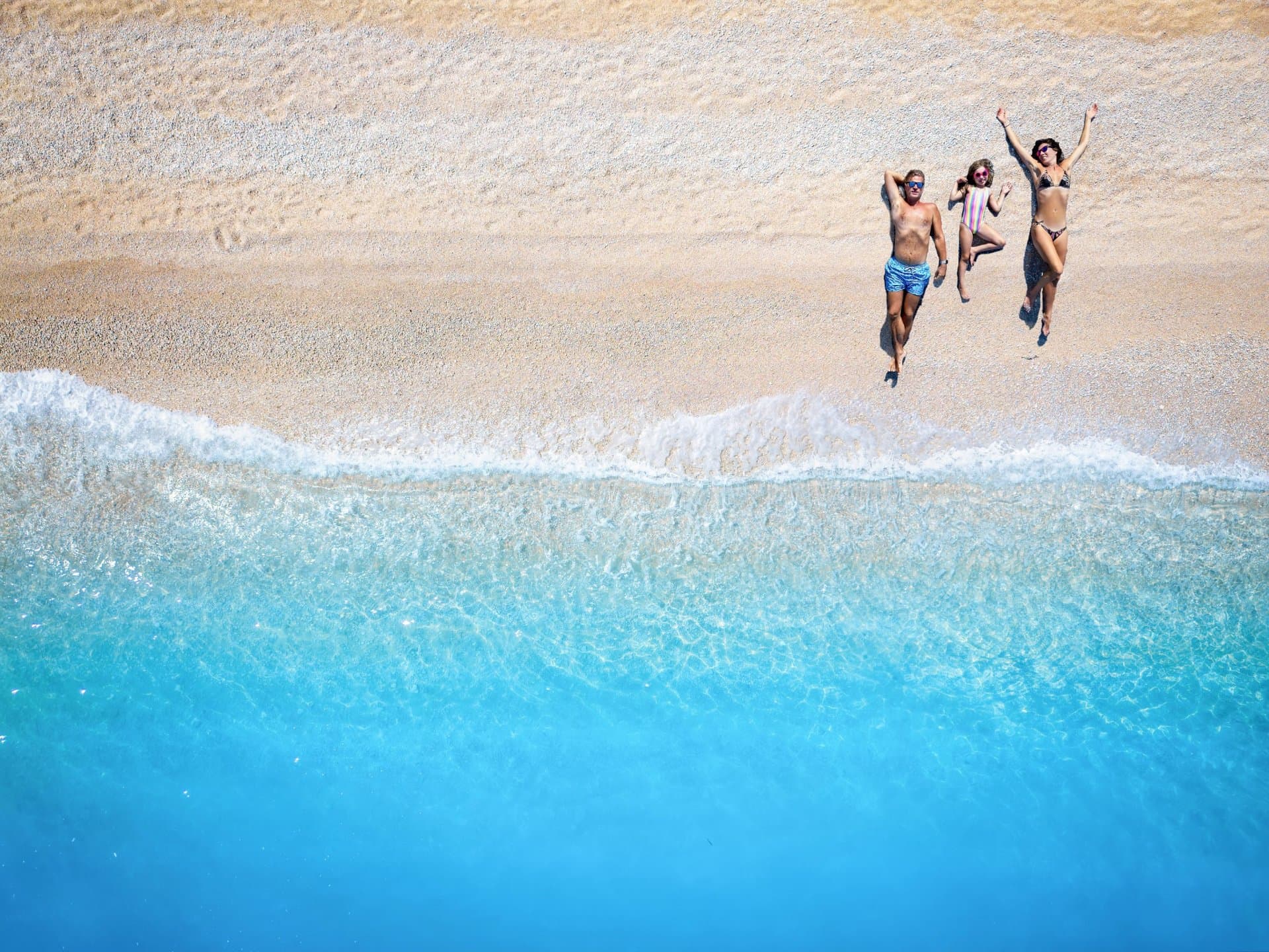 Couple sautant main dans la main dans une eau turquoise - lâcher-prise et énergie